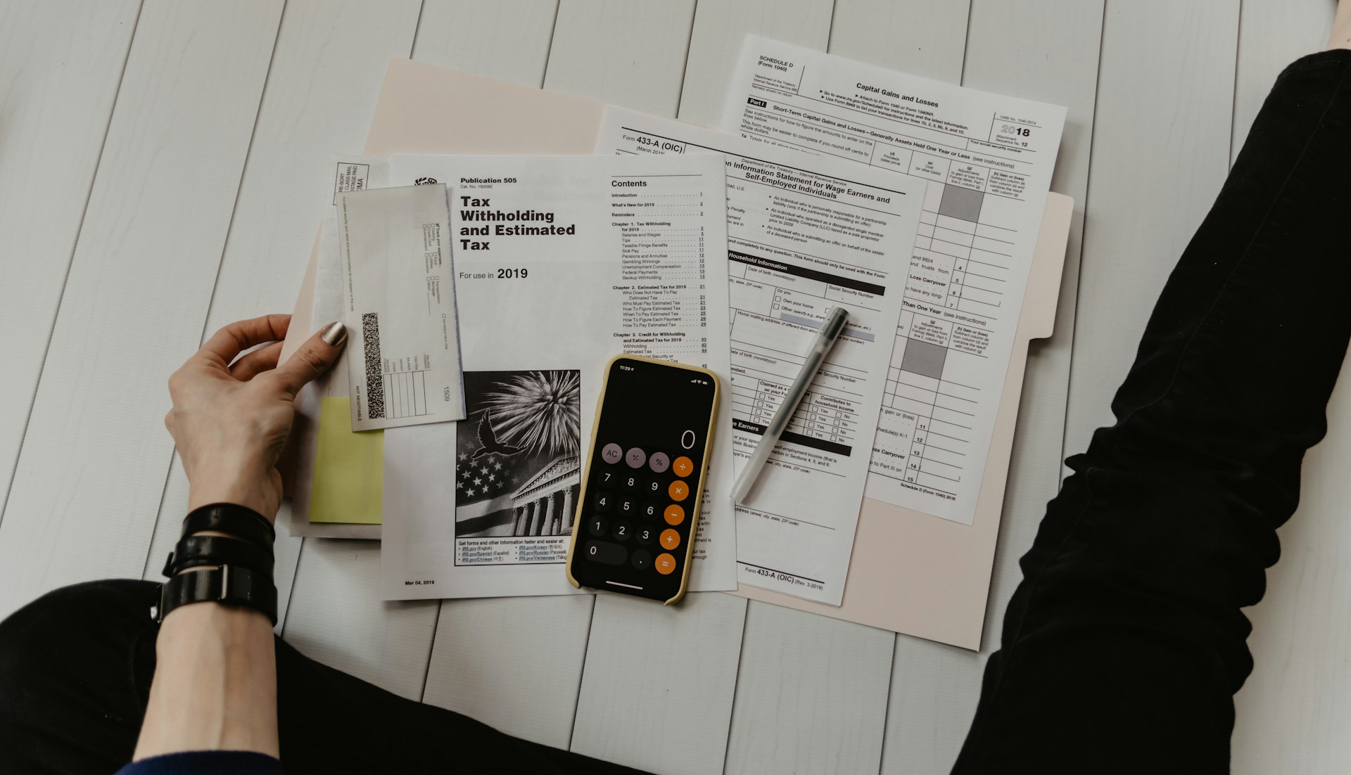 Accounting student calculating balance sheet data on a desk with calculator